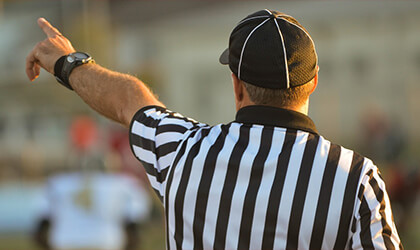A football ref signaling a first down